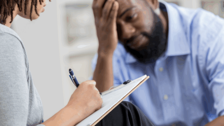 A man expresses stress about his relationship while speaking with a woman therapist in a supportive setting.